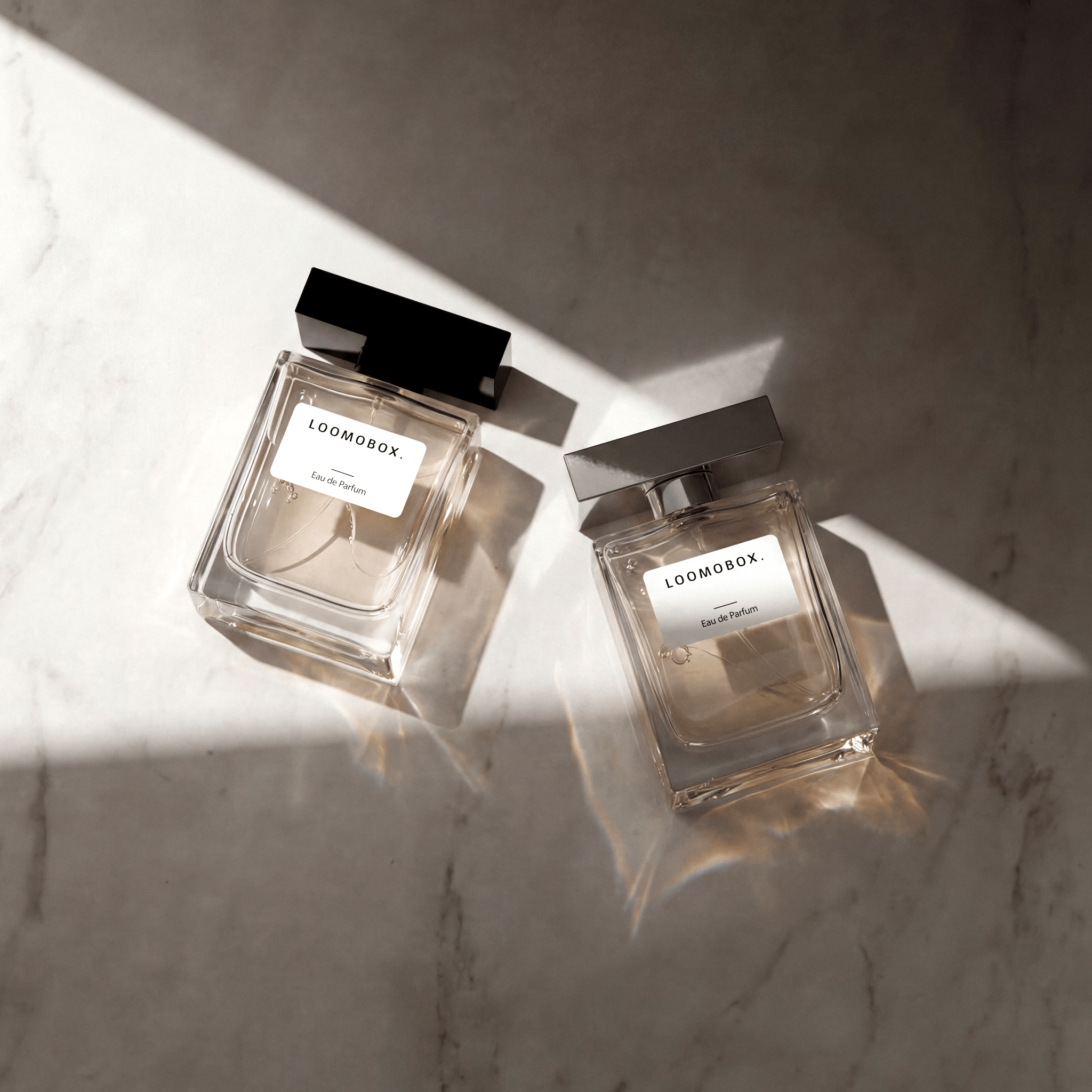 Two eau de parfum flacons lying on light marble in warm sunlight — AI-generated fragrance photography created with loomobox