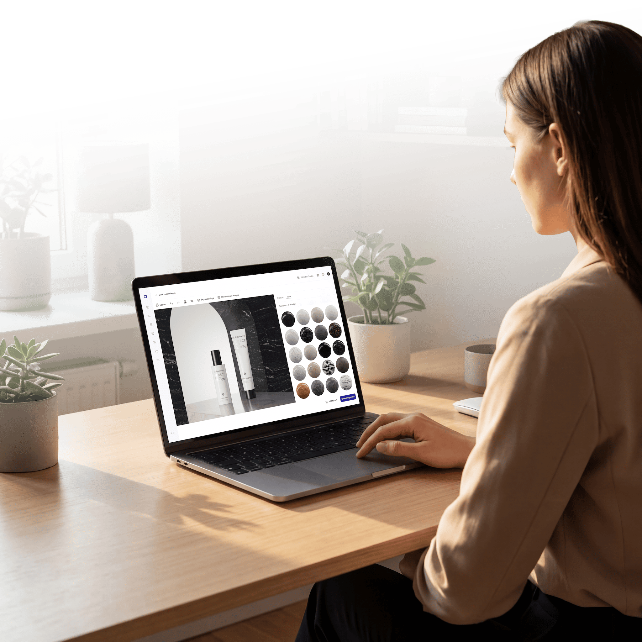 Woman at a desk creating skincare product images in the loomobox Content Studio on her laptop
