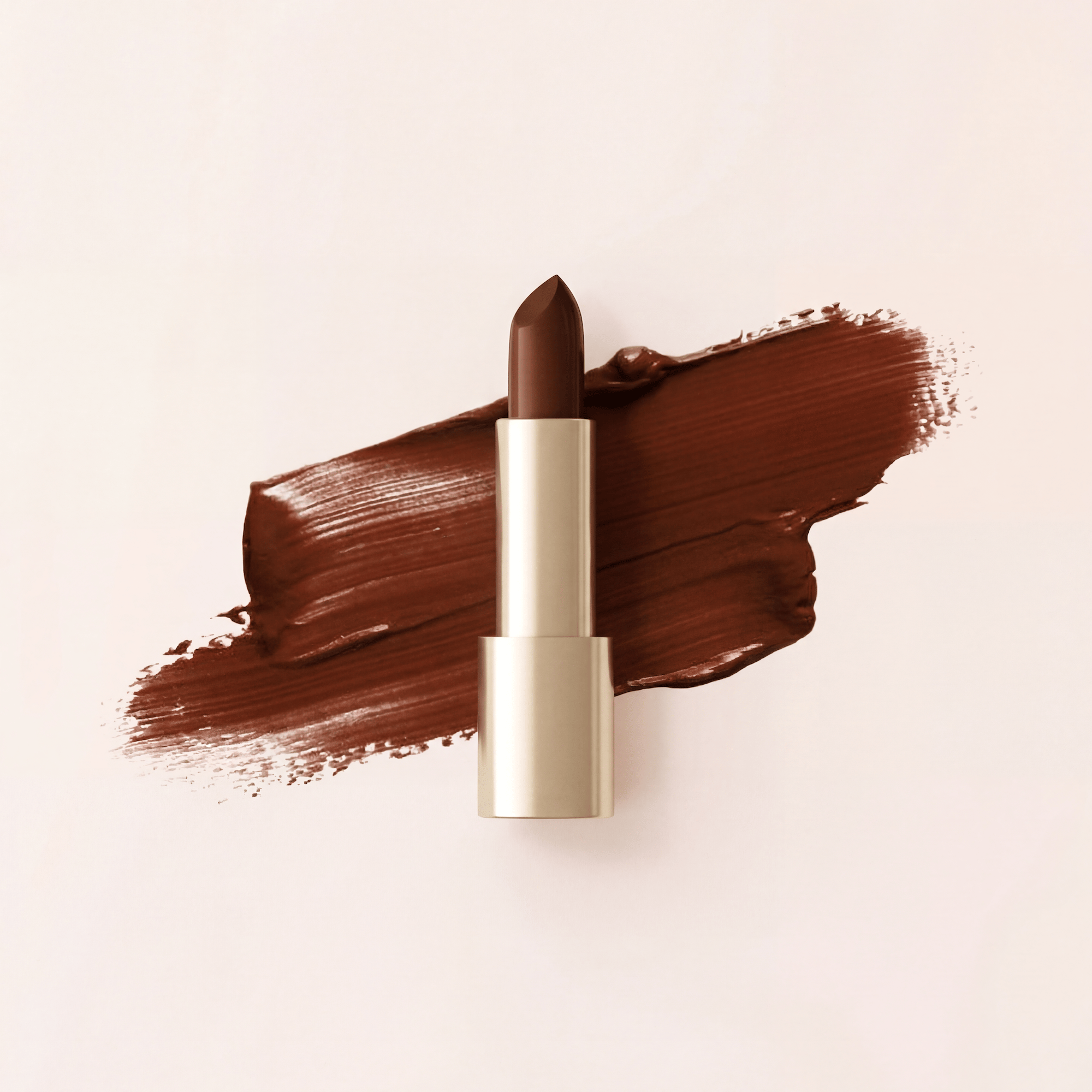 Brown lipstick in gold case on a rich chocolate-toned swatch smear, cosmetics product shot created with loomobox AI