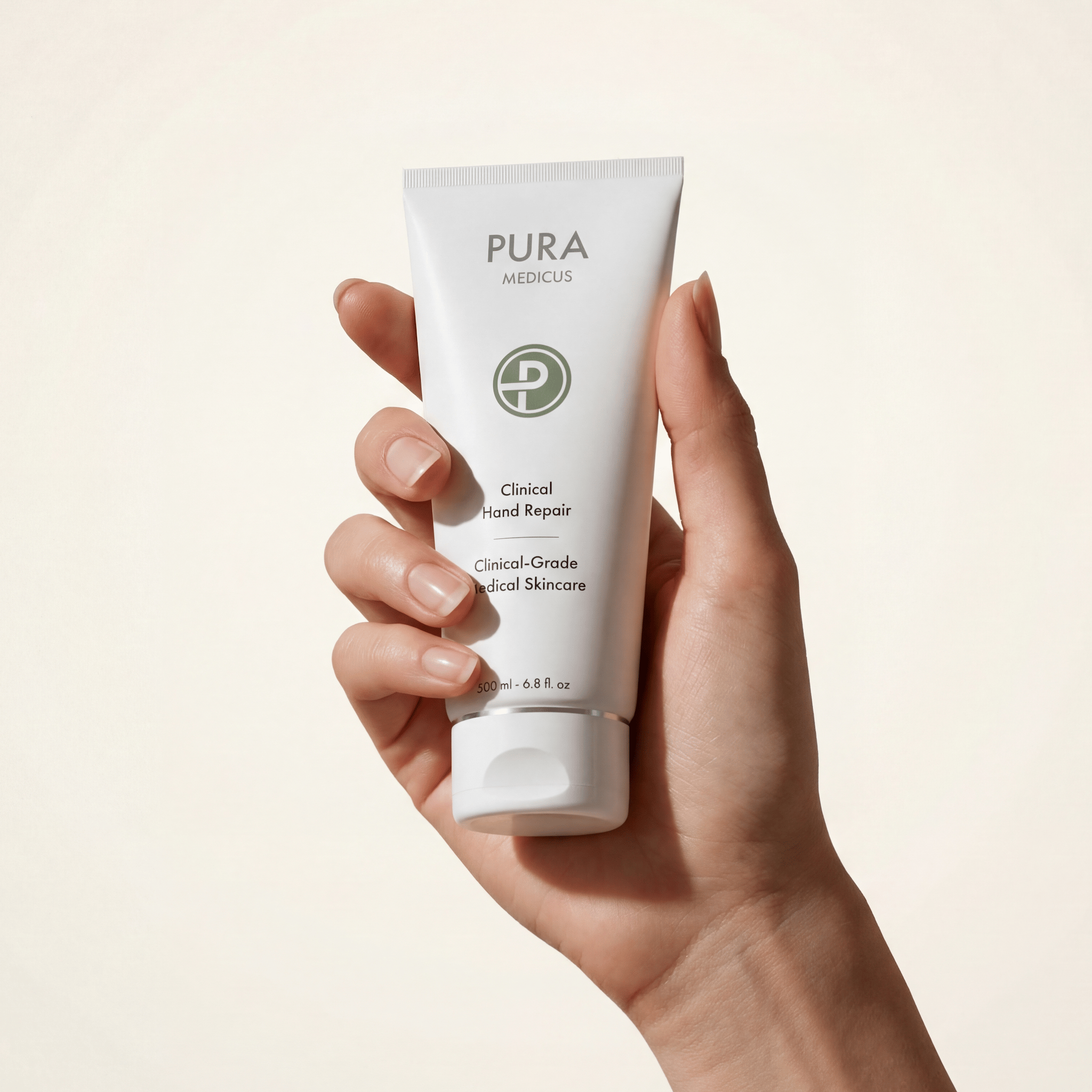 Hand holding a PURA Medicus Clinical Hand Repair tube against a cream backdrop — photorealistic render by loomobox
