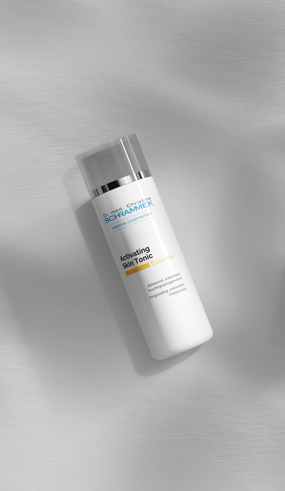 Dr. Schrammek Activating Skin Tonic Essential bottle lying on brushed metal, skincare product shot AI-generated with loomobox
