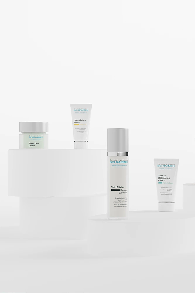 Dr. Schrammek skincare set with Skin Elixir, Special Care Cream and Rosea Calm Cream on white pedestals, rendered with loomobox