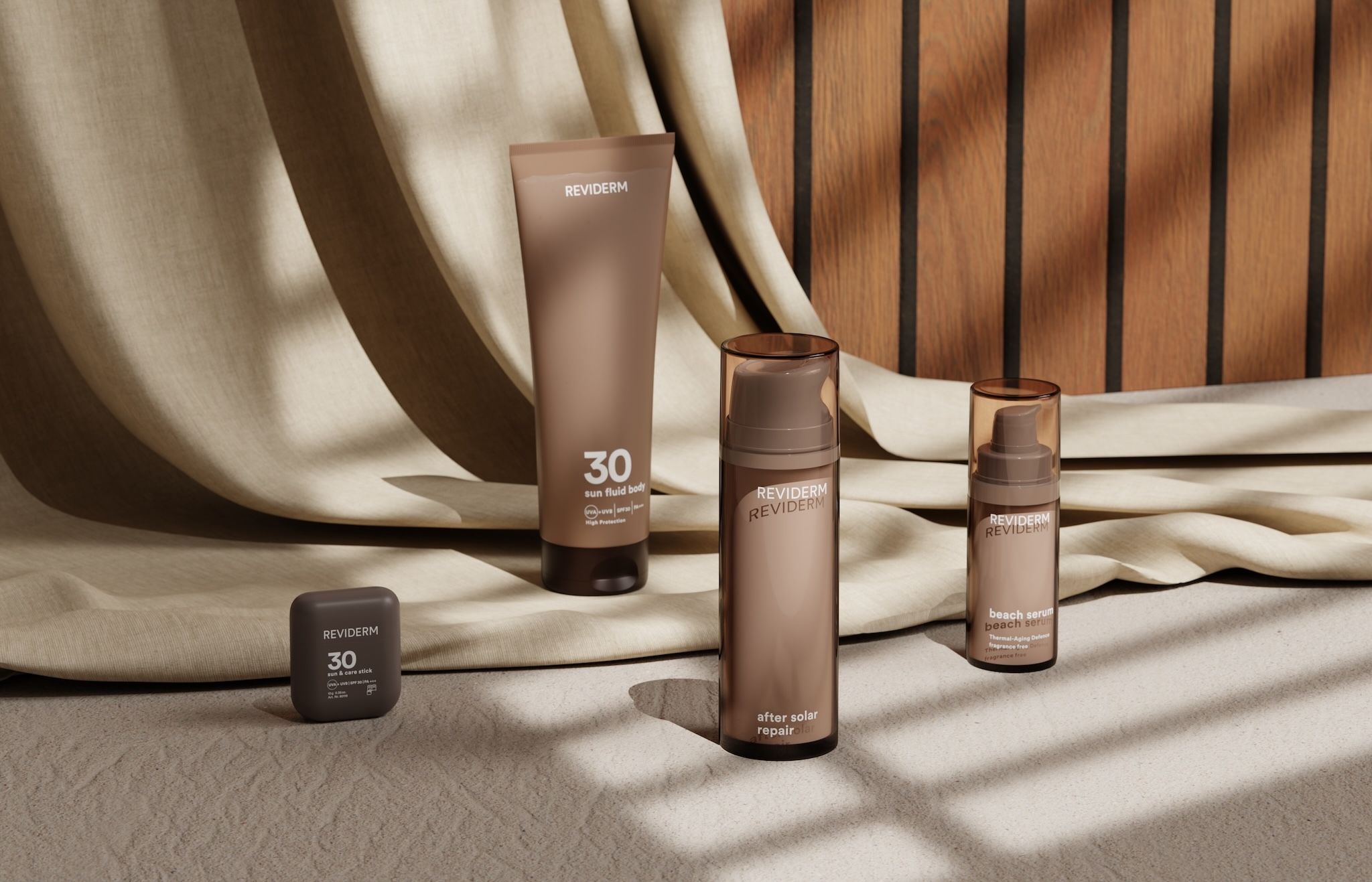 REVIDERM suncare products with sun fluid 30, after solar repair and sun & care stick against a beige curtain and wooden slat wall in sunlight