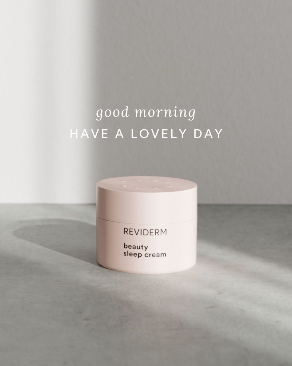 REVIDERM beauty sleep cream jar in soft pink on a grey surface with the message "good morning – have a lovely day"