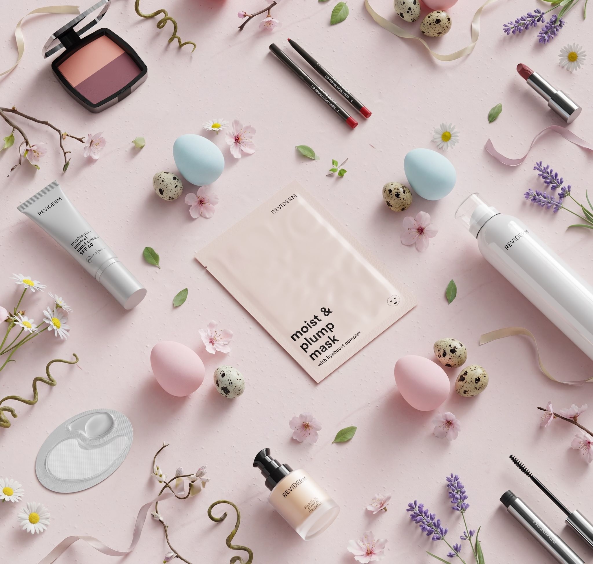 REVIDERM make-up and skincare products in an Easter flatlay on pink with blush palette, lipstick, moist & plump mask and spray among pastel eggs, cherry blossoms, daisies and lavender
