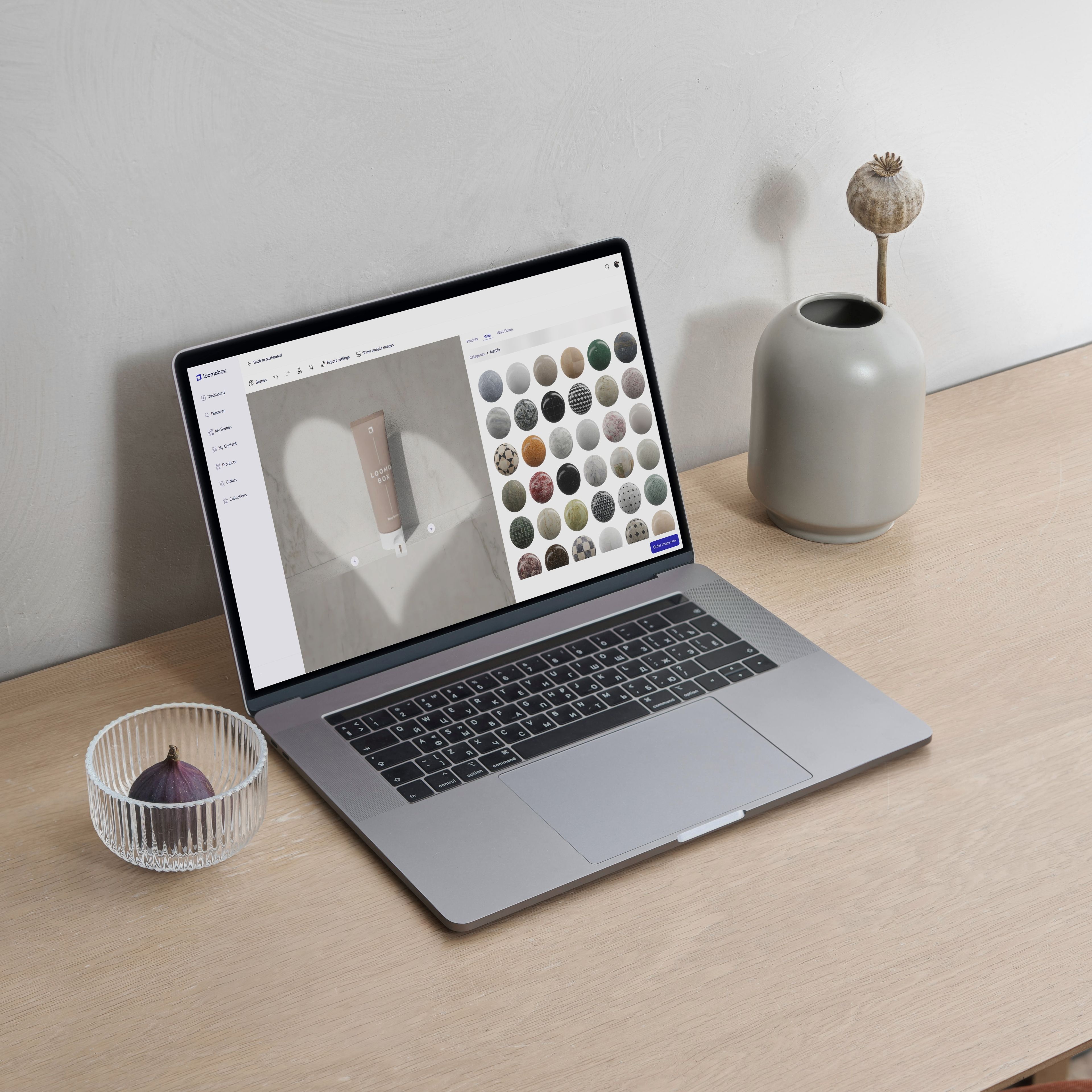 Laptop on a desk showing the loomobox Content Studio with a cosmetic tube and the material picker open