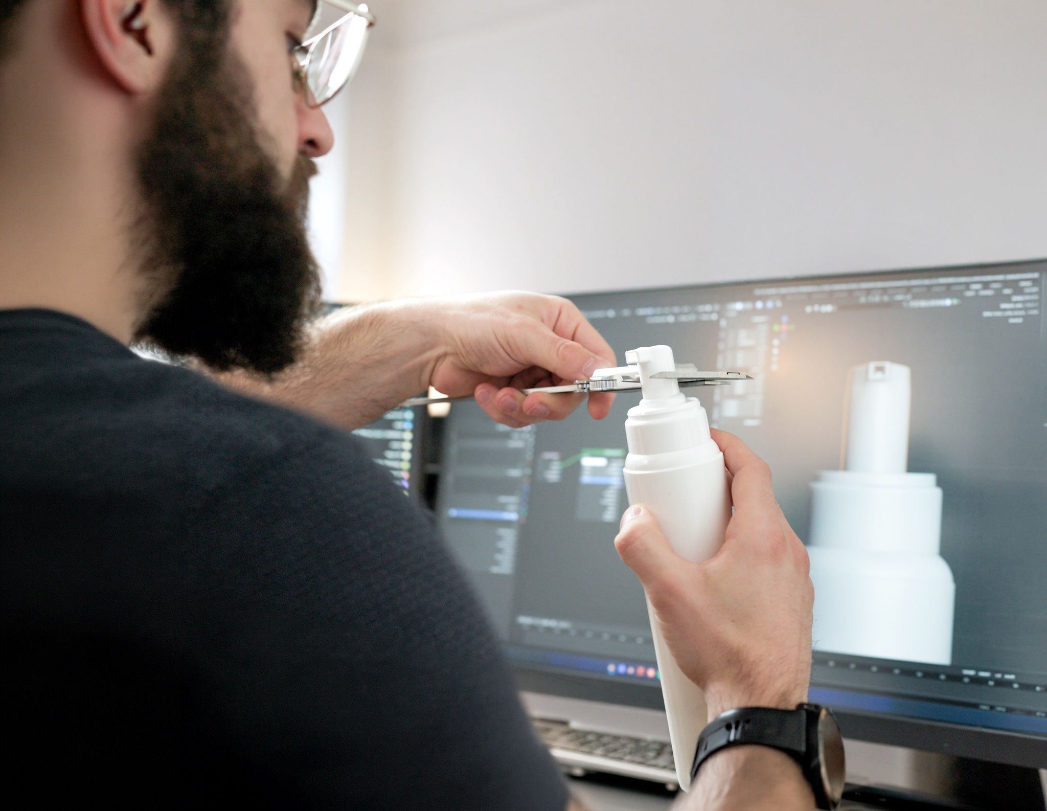 loomobox team member measuring a skincare bottle with calipers to build its exact 3D digital twin