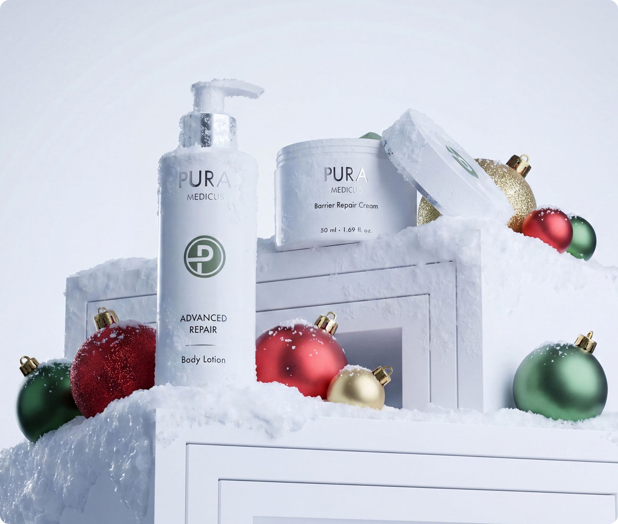 Skincare lotion and cream jar in a snowy Christmas scene with red, green and gold baubles, created with loomobox